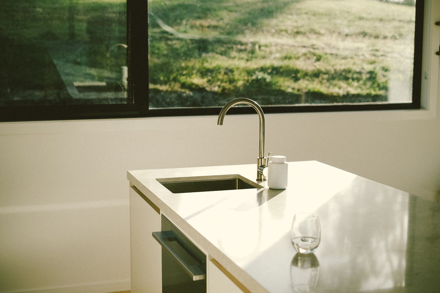 A kitchen sink and faucet in a dark, quiet house